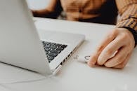 Close-up of a person inserting a USB drive into a laptop, symbolizing technology and data connection.
